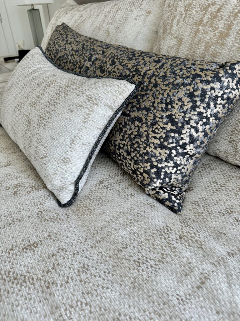 A close up of pillows in contrasting fabric and beaded trim